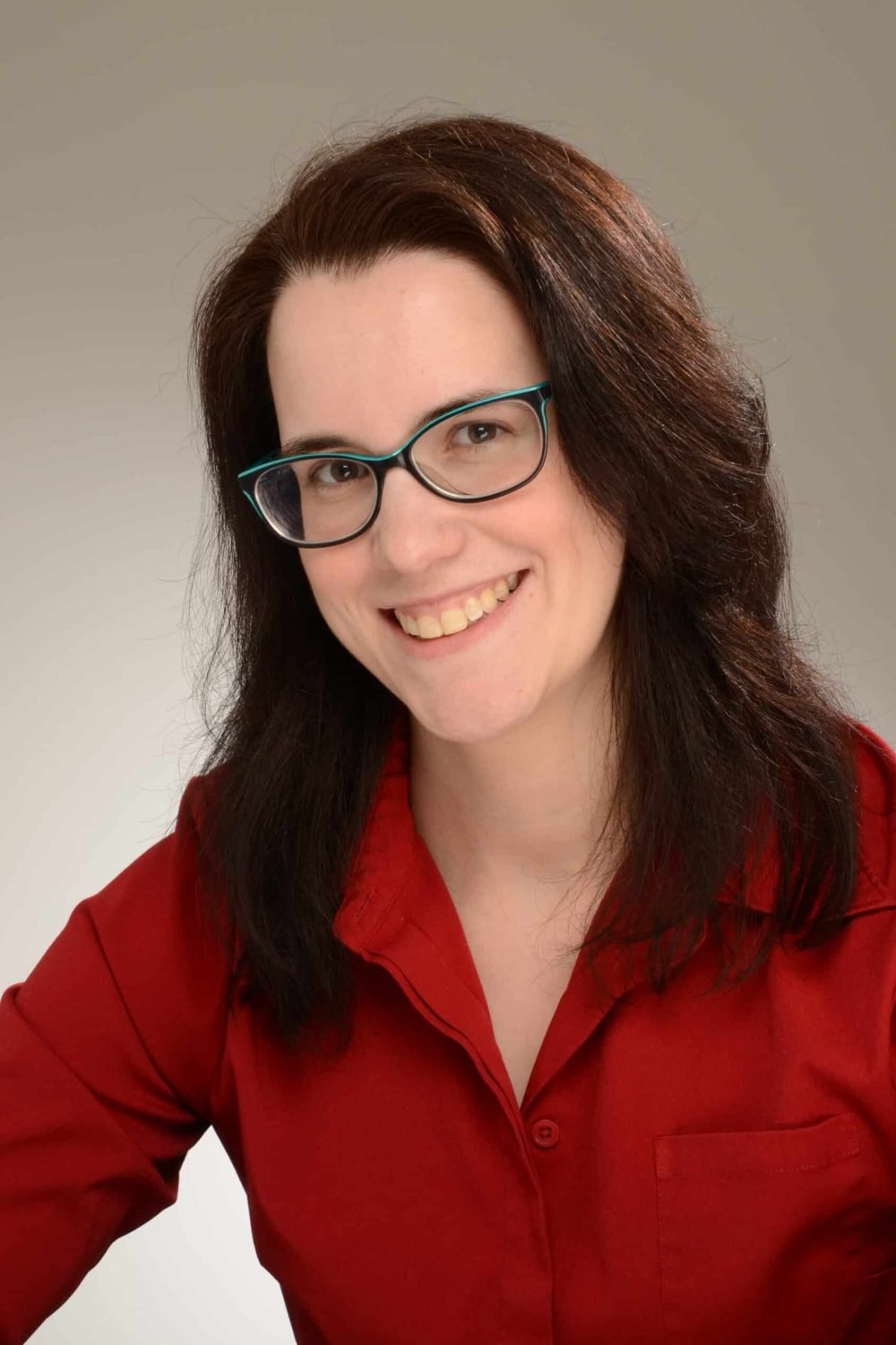 Smiling woman with glasses wearing a red shirt portrait